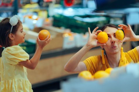 Funny Mom and Daughter Shopping for Oranges in a Grocery Store